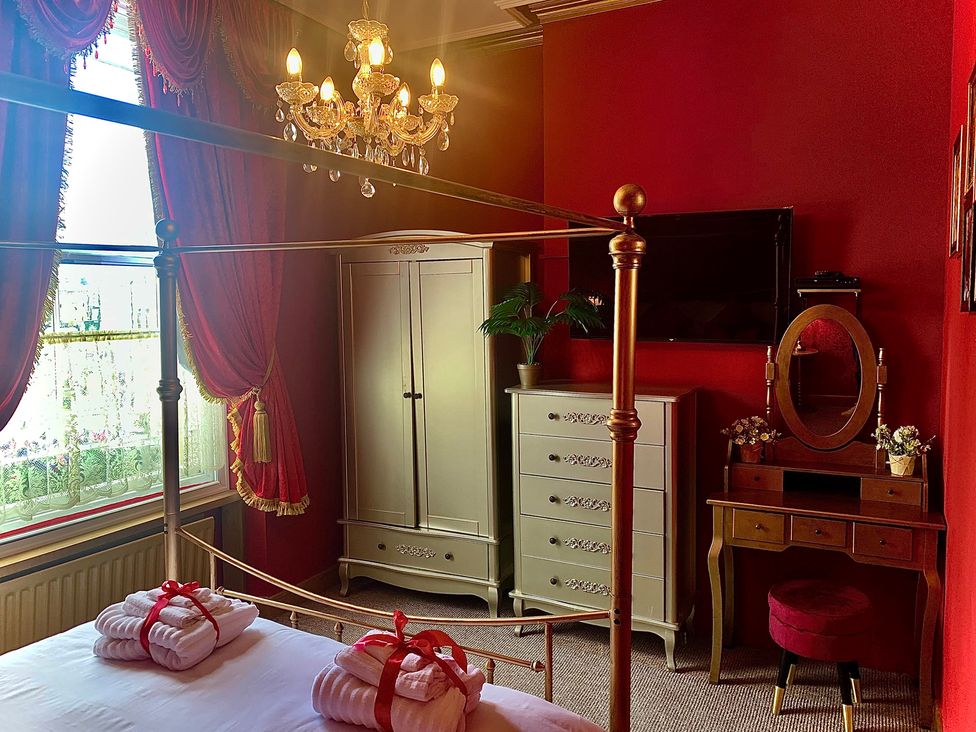 A bedroom with a bed and a chandelier at Downton I in Alnwick