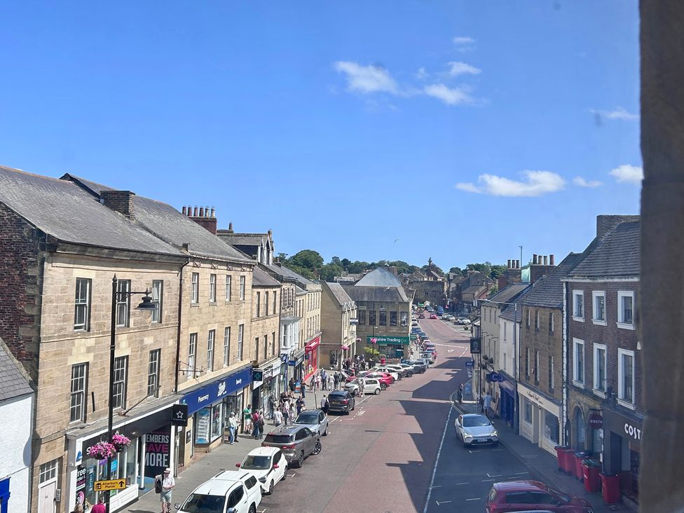 A street view with shops and vehicles at Downton I in Alnwick