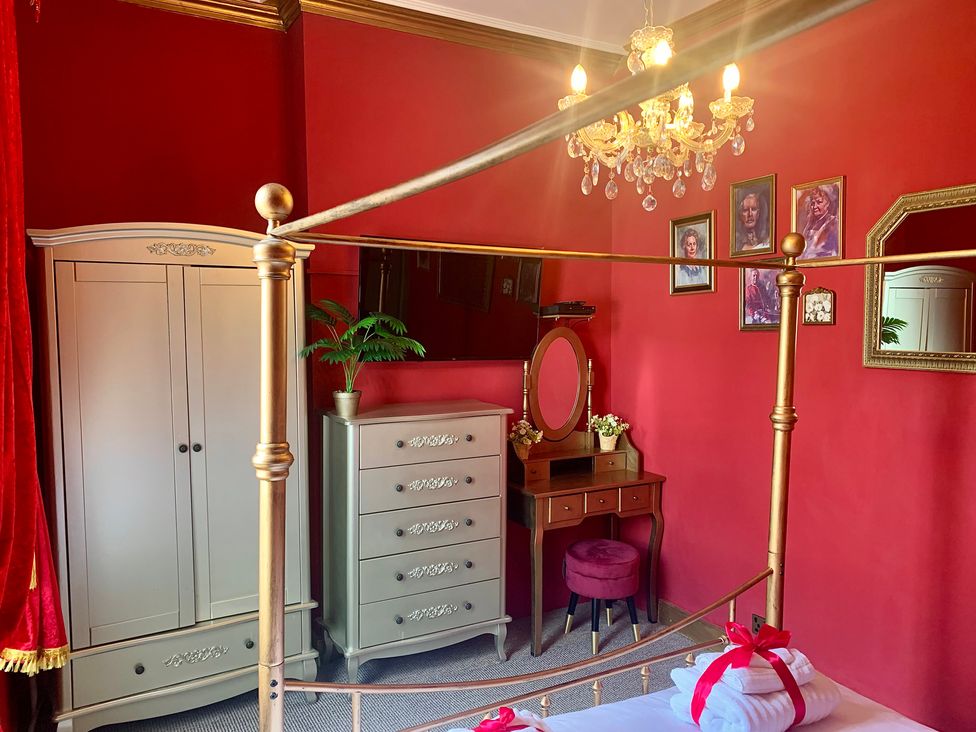 A bedroom with a bed, wardrobe, dresser, and vanity at Downton I in Alnwick