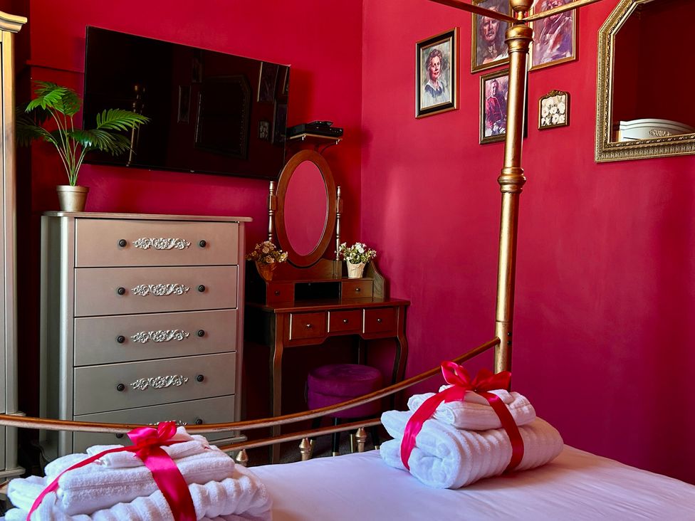 A bedroom with a bed, television, and mirror at Downton I in Alnwick