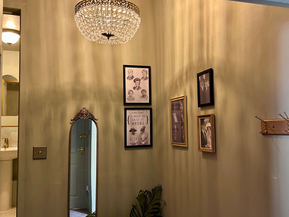 A hallway with photos and a mirror at Downton I in Alnwick