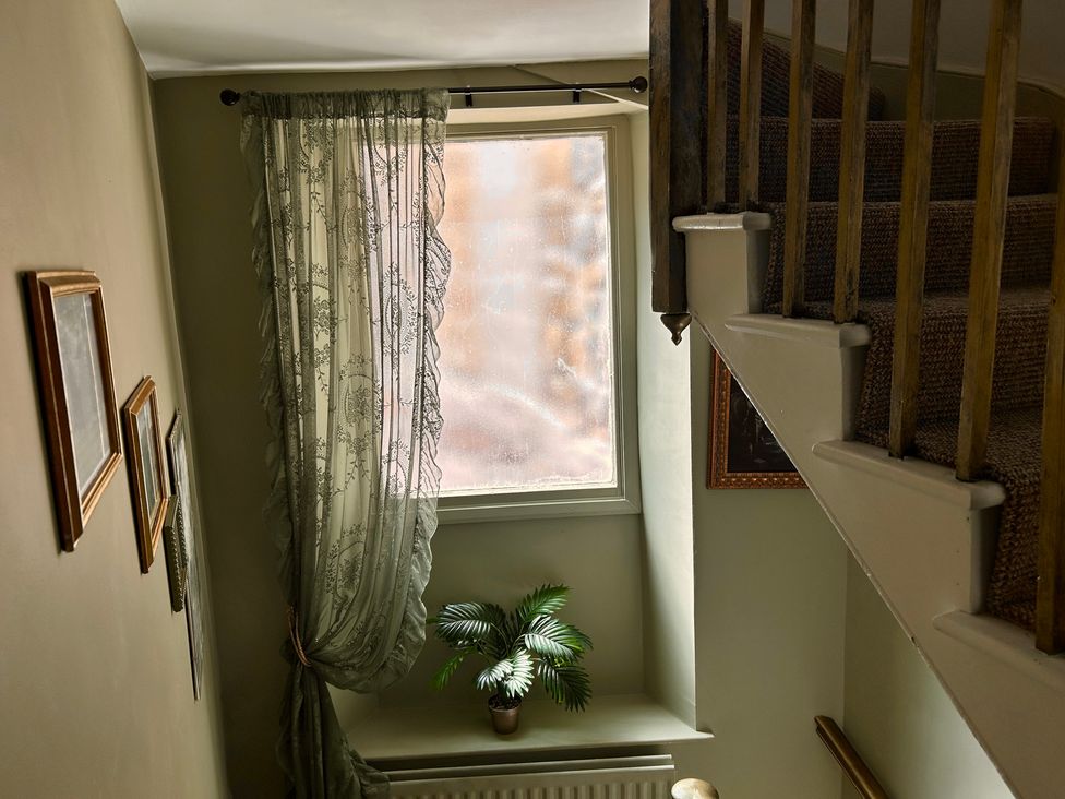 A staircase with a window and pictures at Downton I, Alnwick