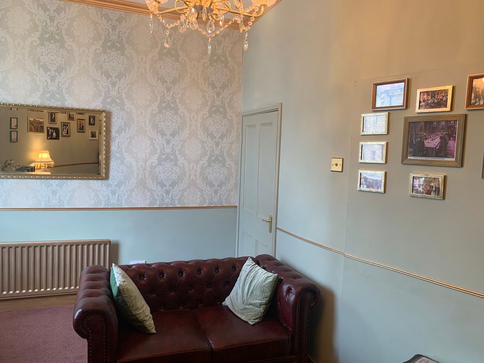 A living room with a sofa and mirror at Downton I in Alnwick