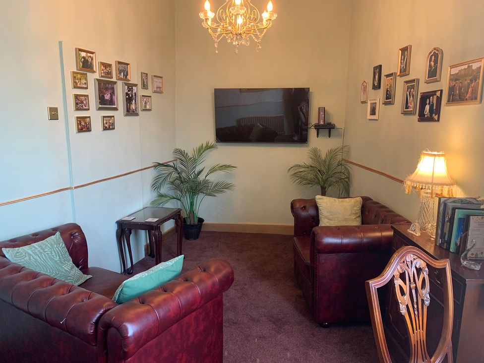 A living room with a television and leather sofas at Downton I in Alnwick