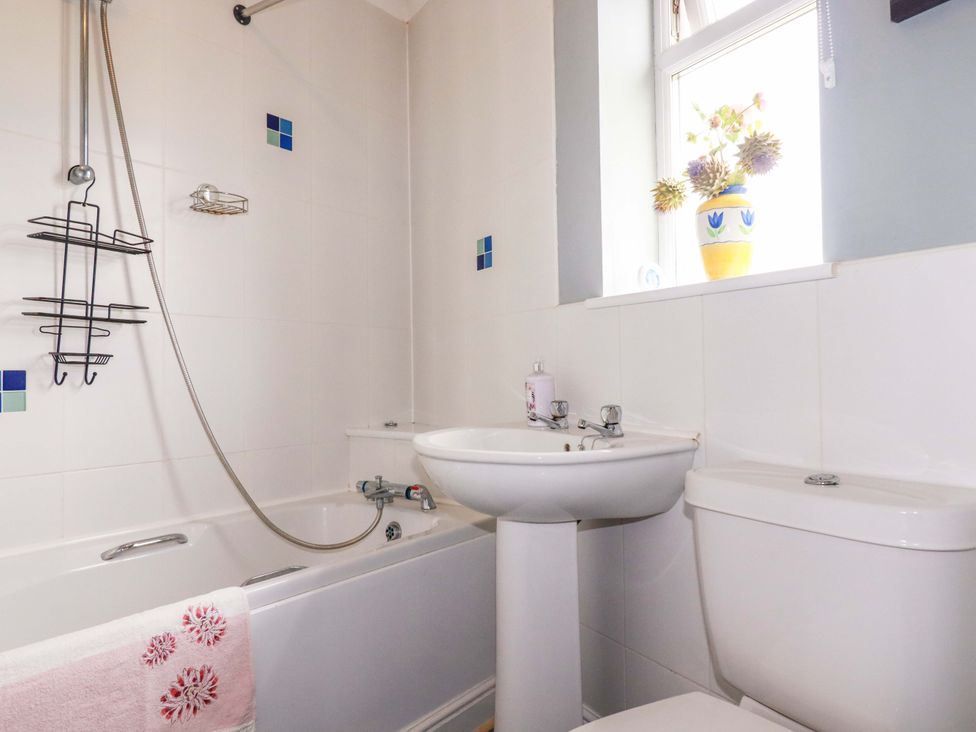 A bathroom with a bathtub, sink, and toilet at Treetops in Par
