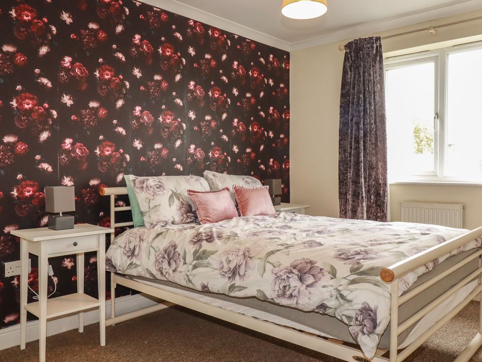 A bedroom with a bed and bedside table at Treetops St Blazey