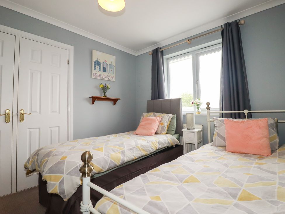 A bedroom with two beds and a window at Treetops in St Blazey