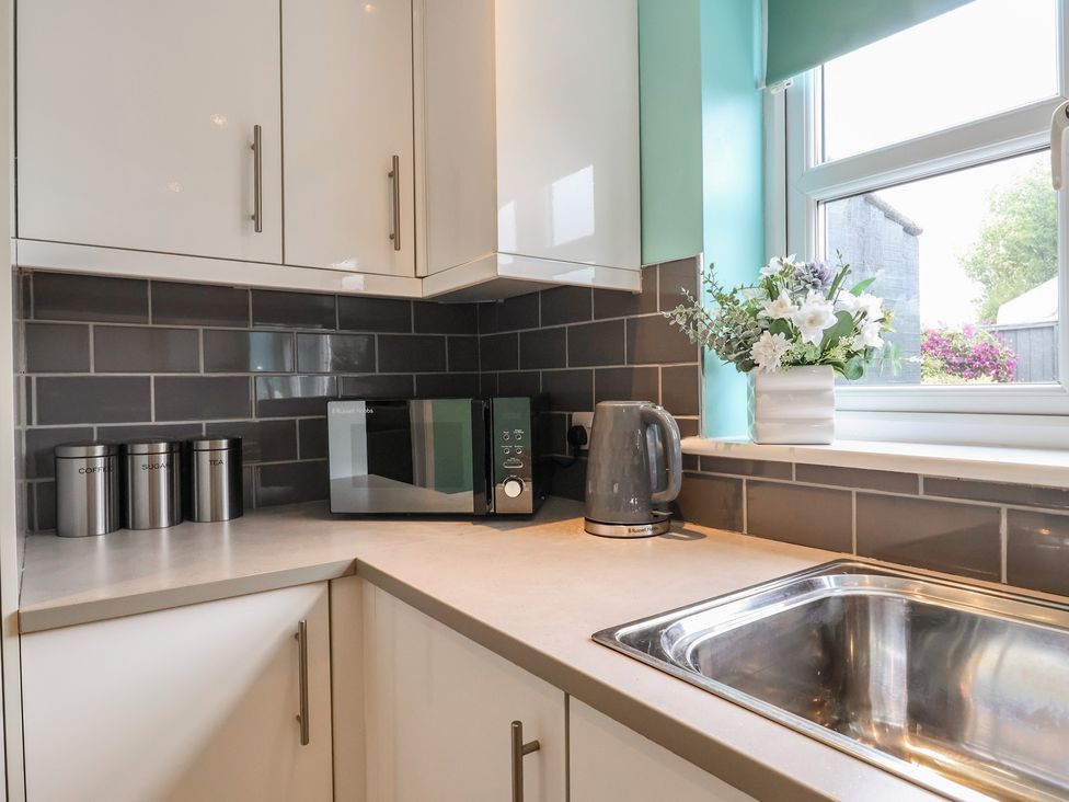 A kitchen with a microwave, kettle, and sink at Frome View Wool