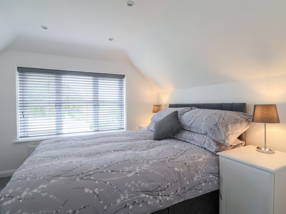 A bedroom with a bed and lamps at Frome View Wool