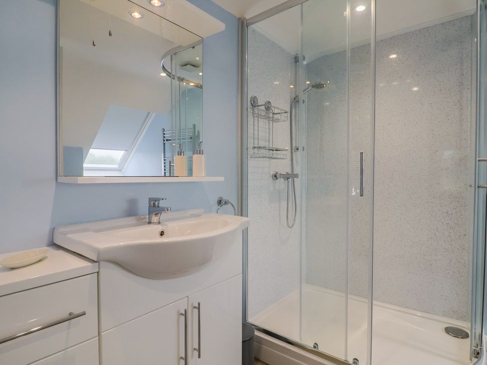 A bathroom with a sink, shower, and mirror at Frome View in Wool