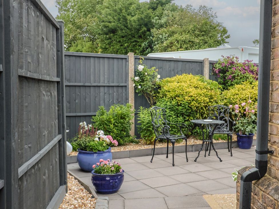 A garden with potted plants and a patio table and chairs at Frome View in Wool