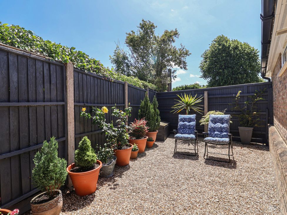 A garden with potted plants and chairs at Frome View, Wool