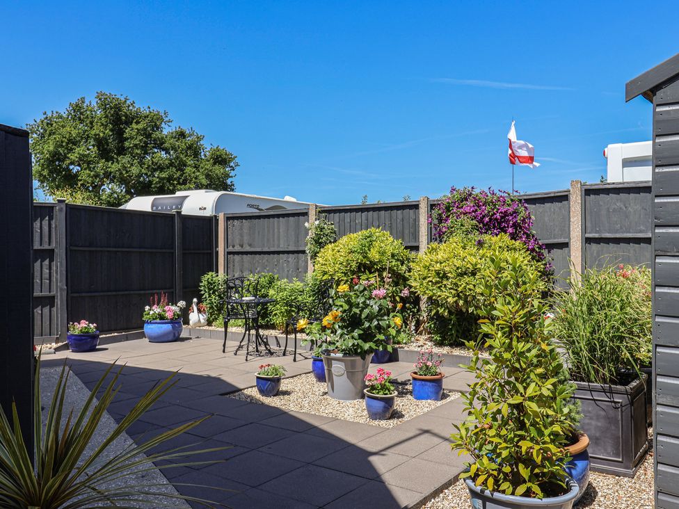 A garden with potted plants and seating at Frome View Wool