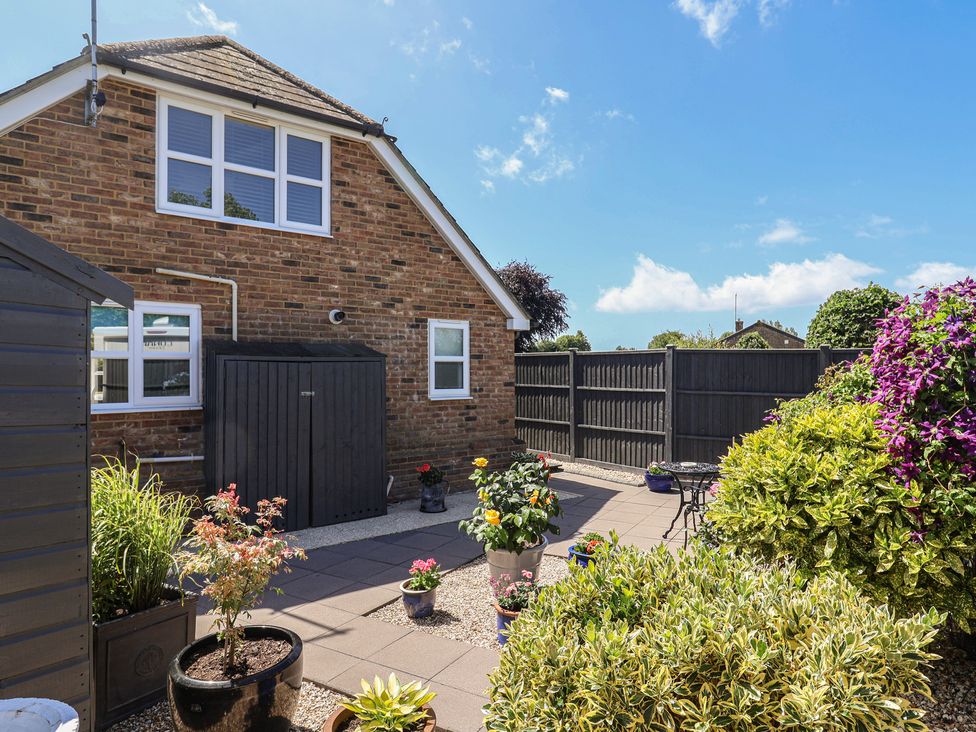 A garden with a paved area and shed at Frome View in Wool