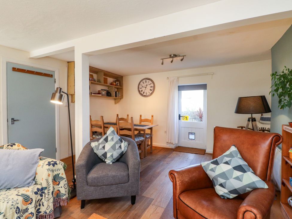 A living room with a sofa and armchair at Scoops’ Nook in Caernarfon