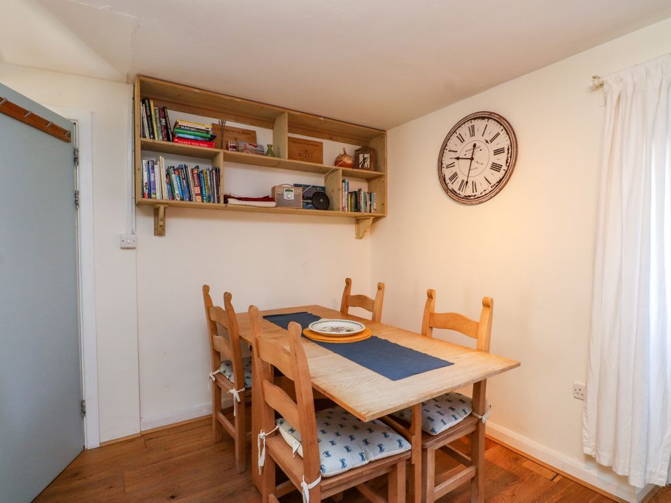 A dining room with a table and chairs at Scoops’ Nook in Caernarfon