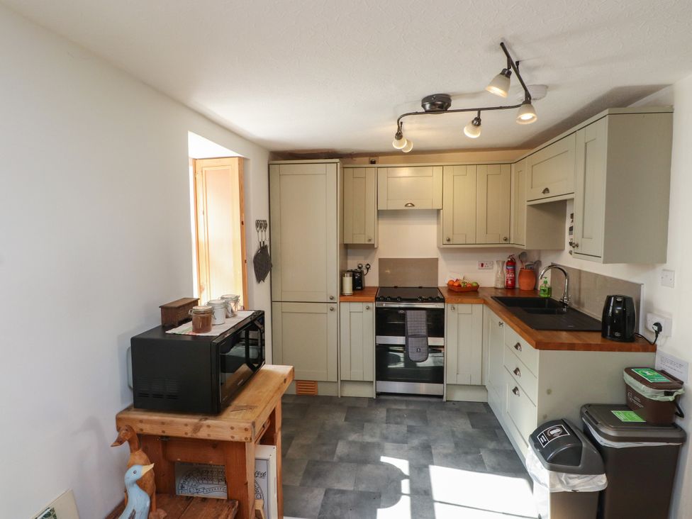 A kitchen with cabinets and appliances at Scoops’ Nook Caernarfon
