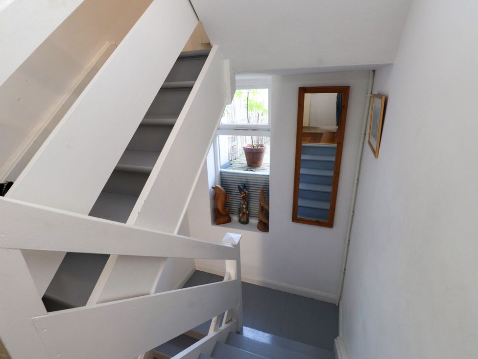 A staircase with a mirror and window at Scoops’ Nook in Caernarfon