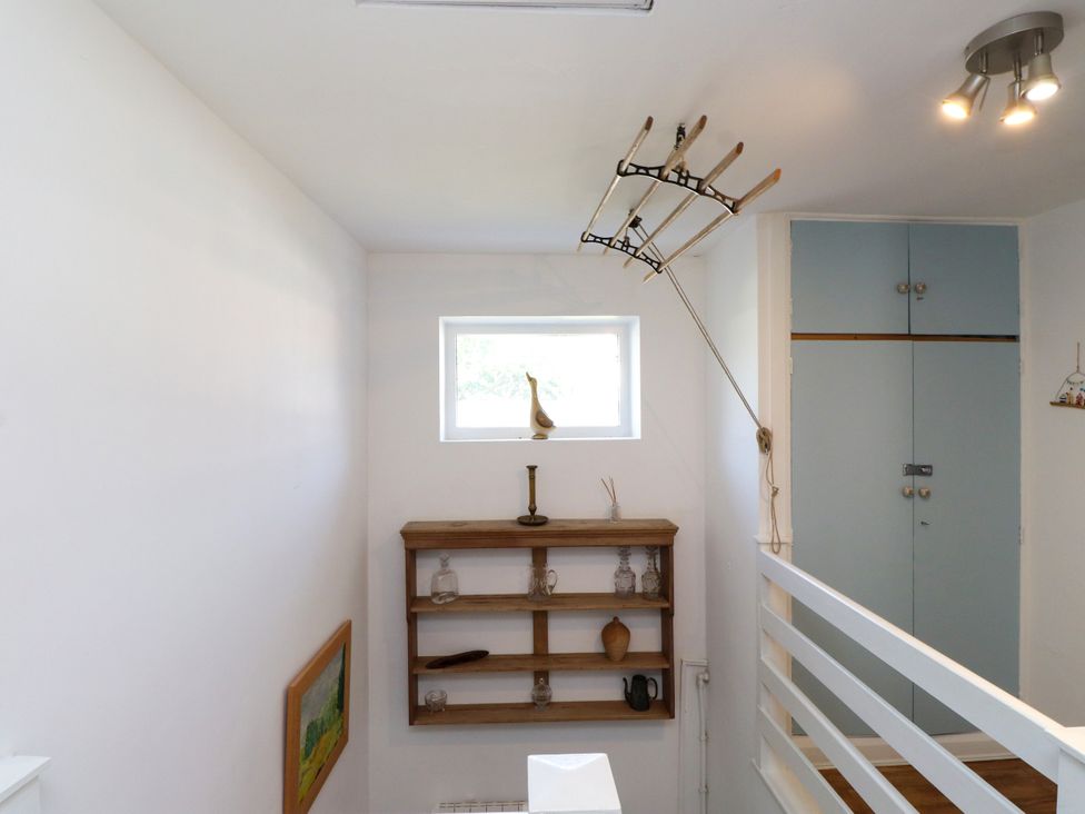 A hallway with a shelf and window at Scoops’ Nook in Caernarfon