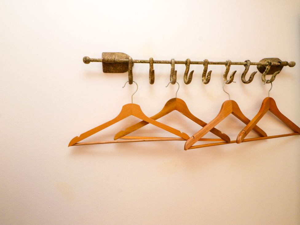 A wall with hooks and wooden hangers at Scoops’ Nook in Caernarfon