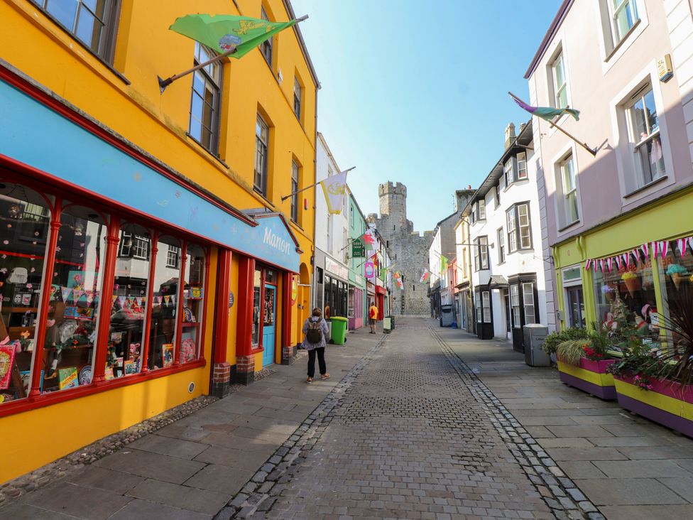 A street with shops and a castle at Scoops’ Nook in Caernarfon