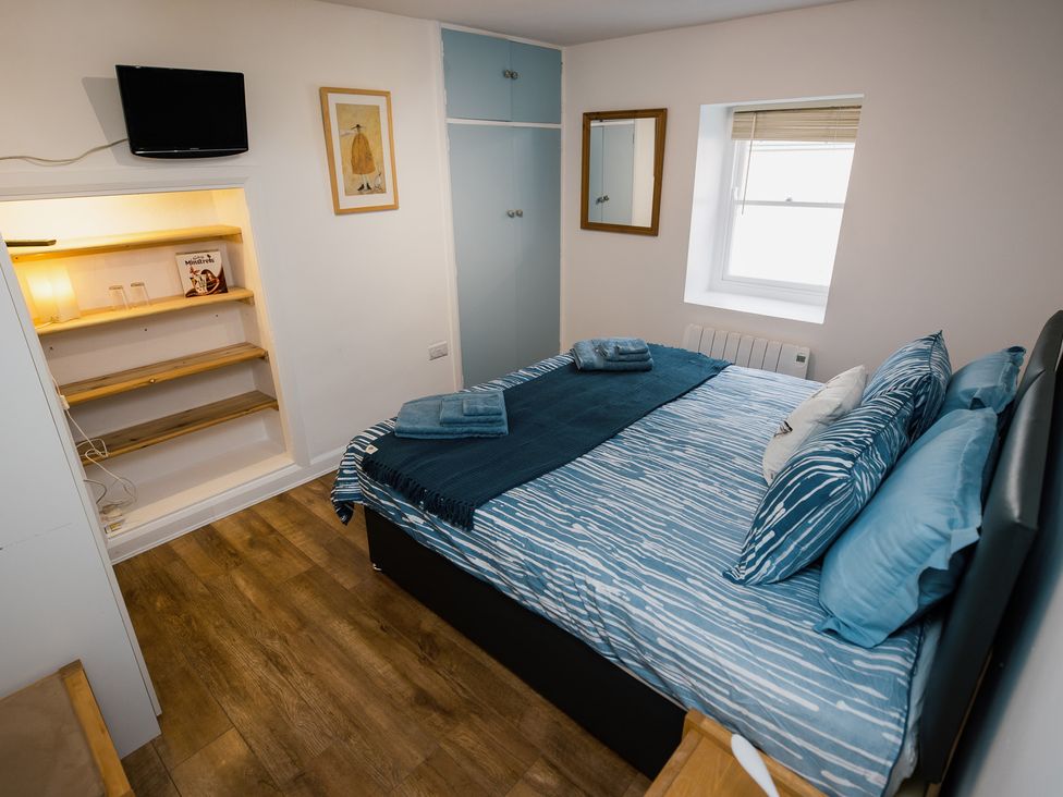 A bedroom with a bed and television at Scoops’ Nook in Caernarfon