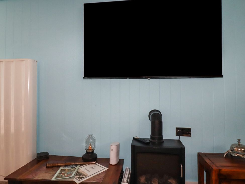 A living room with a television and stove at 31 Tregoney Hill Mevagissey