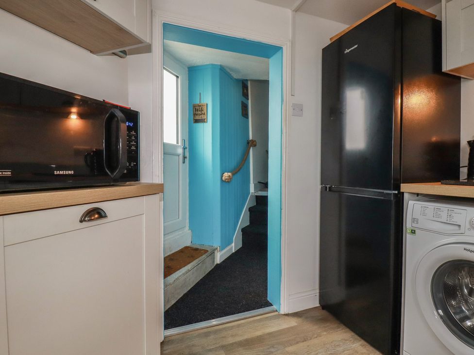 A kitchen with a microwave and fridge at 31 Tregoney Hill Mevagissey