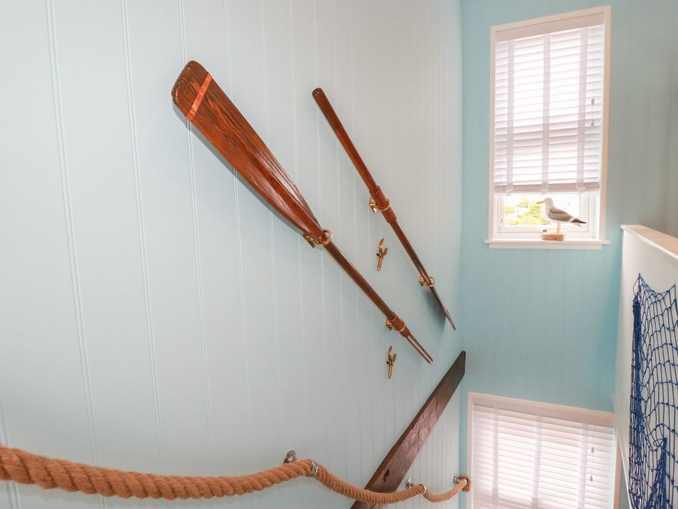 A staircase with wooden oars and decorative items at 31 Tregoney Hill Mevagissey