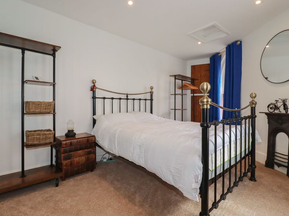 A bedroom with a bed and shelves at 31 Tregoney Hill Mevagissey