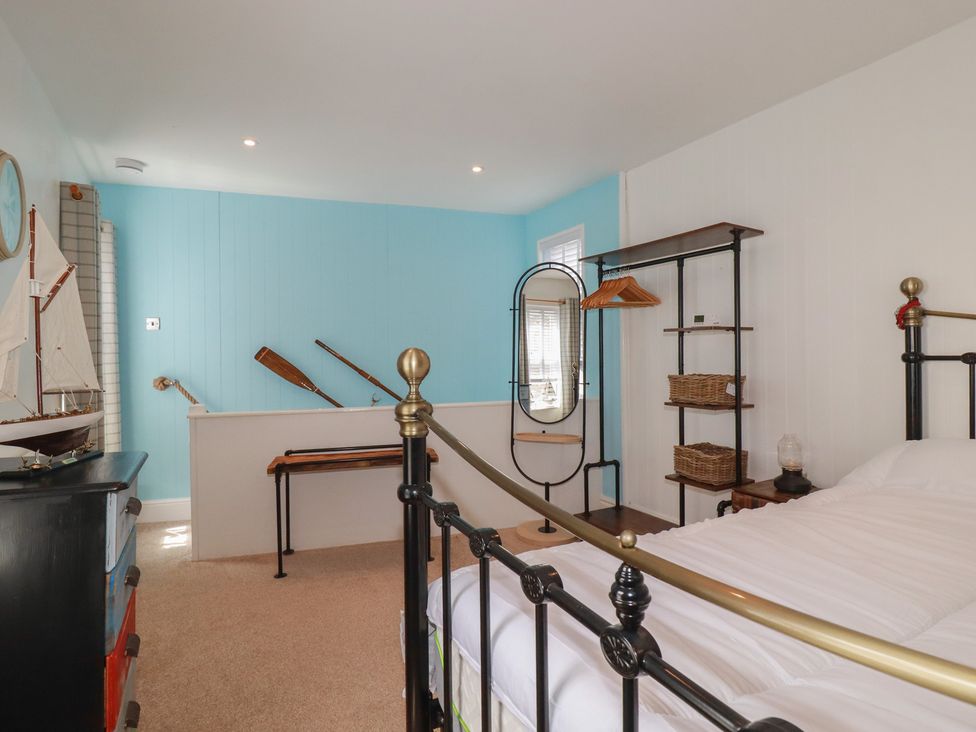 A bedroom with a bed and a dressing mirror at 31 Tregoney Hill in Mevagissey