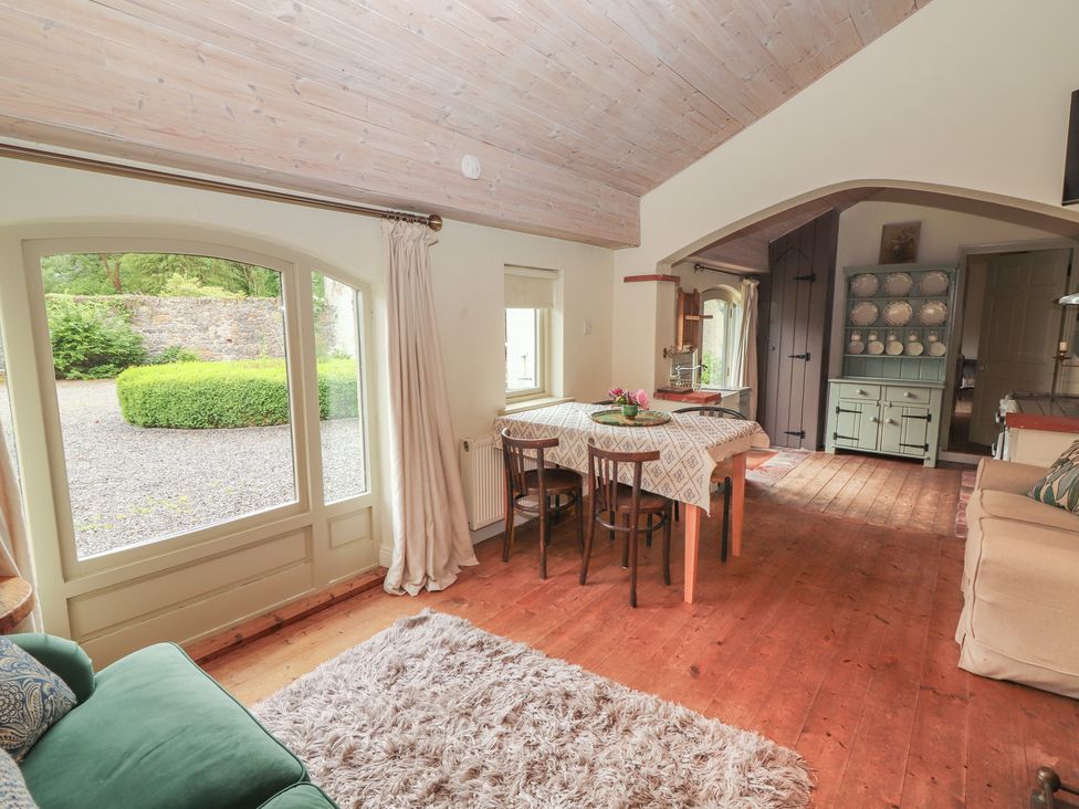 A dining room with a table and chairs at The Coach House Cottage BALLYCOMMON