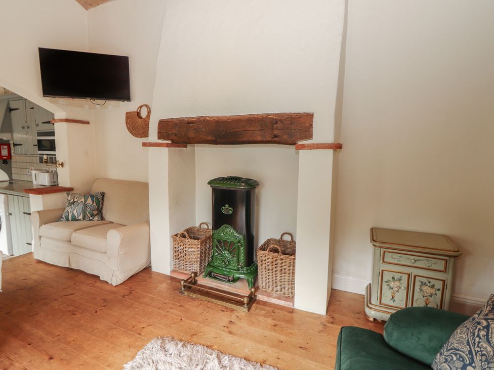 A living room with a sofa and television at The Coach House Cottage BALLYCOMMON