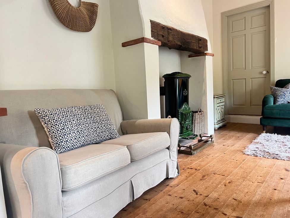 A living room with a sofa and fireplace at The Coach House Cottage Ballycommon