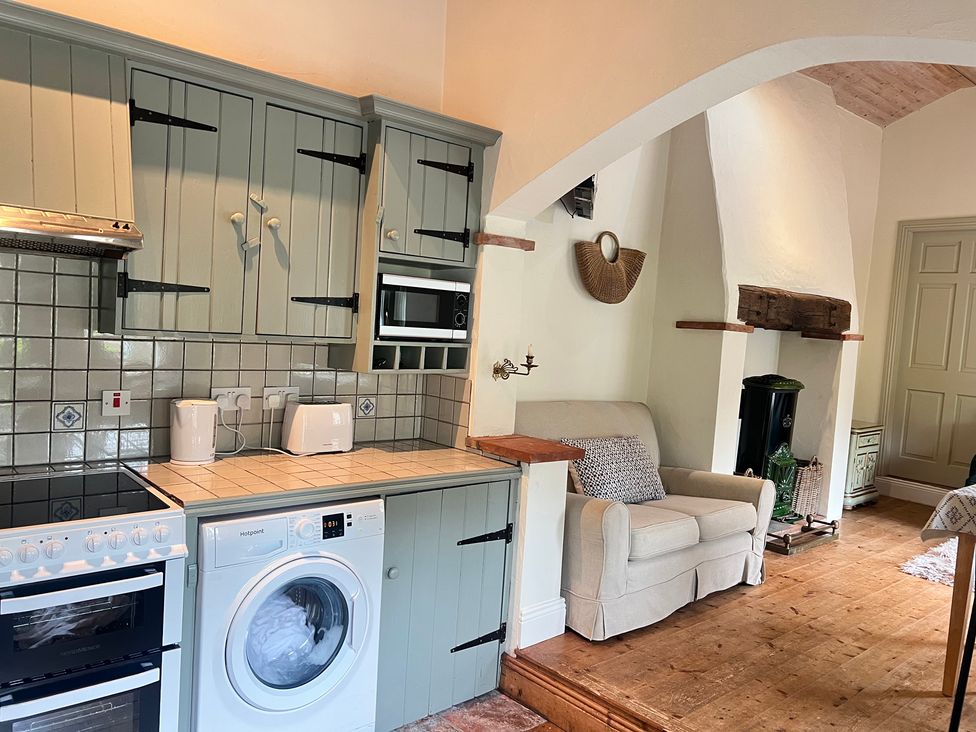 A kitchen with appliances and a couch at The Coach House Cottage Ballycommon