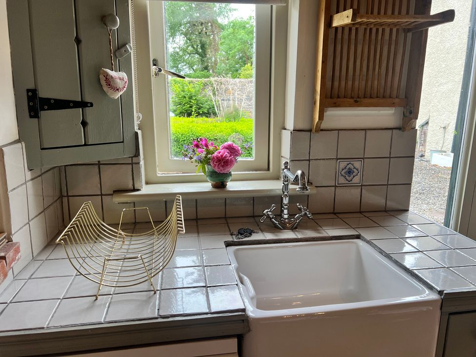 A kitchen with a sink and a flower vase at The Coach House Cottage Ballycommon