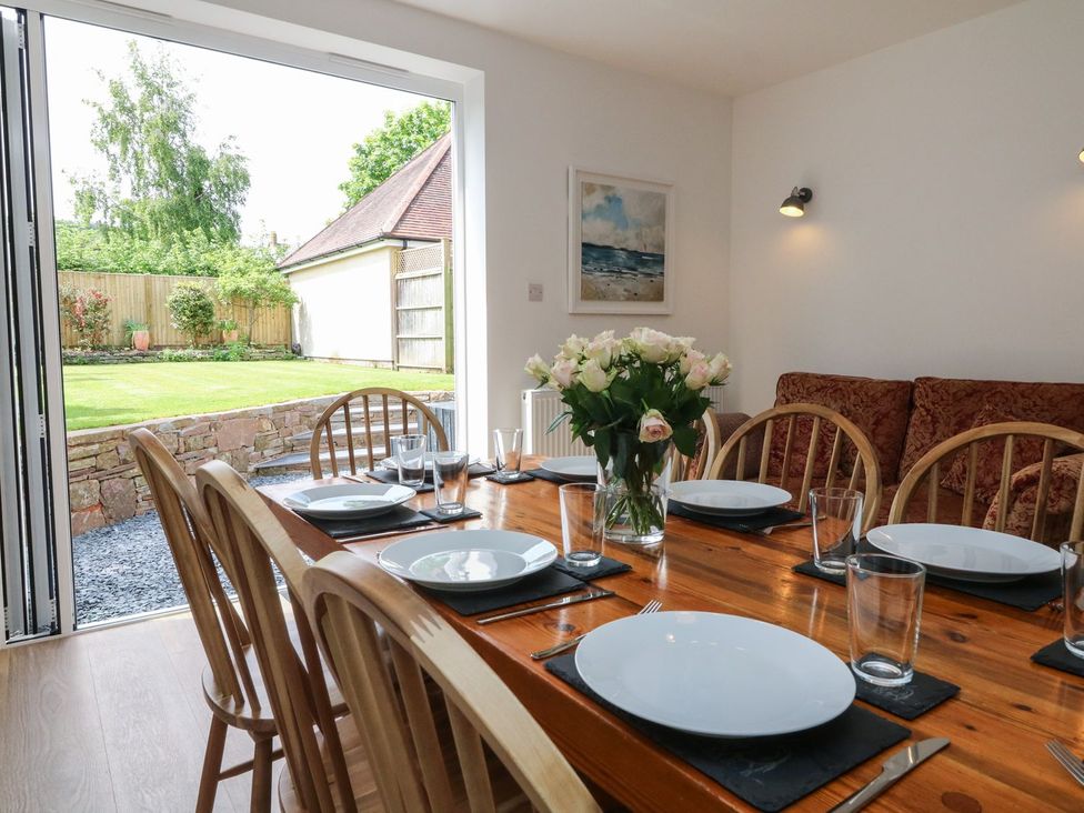 A dining room with a table set for dinner at Wendy's Cottage Minehead