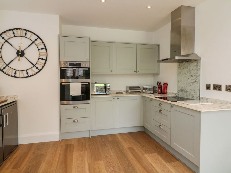A kitchen with cabinets and appliances at Wendy's Cottage in Minehead