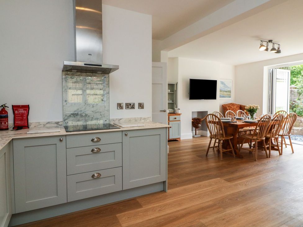 A kitchen area with dining table and chairs at Wendy's Cottage in Minehead