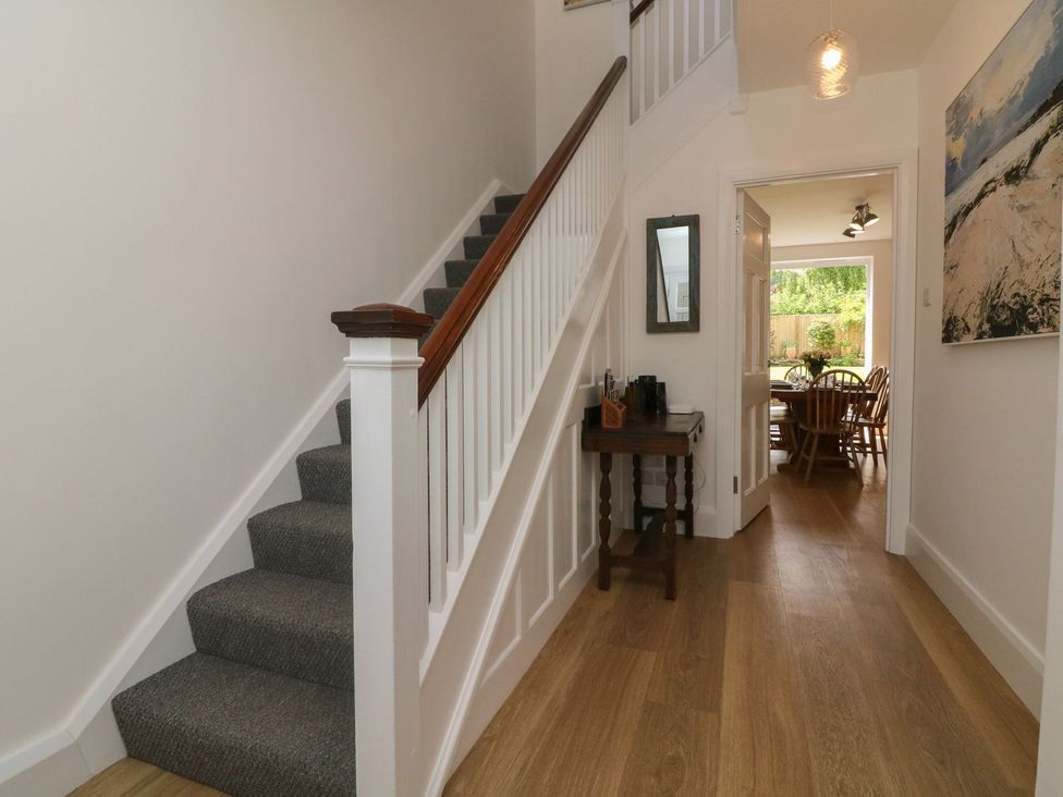 A hallway with a staircase and a dining area visible at Wendy's Cottage in Minehead