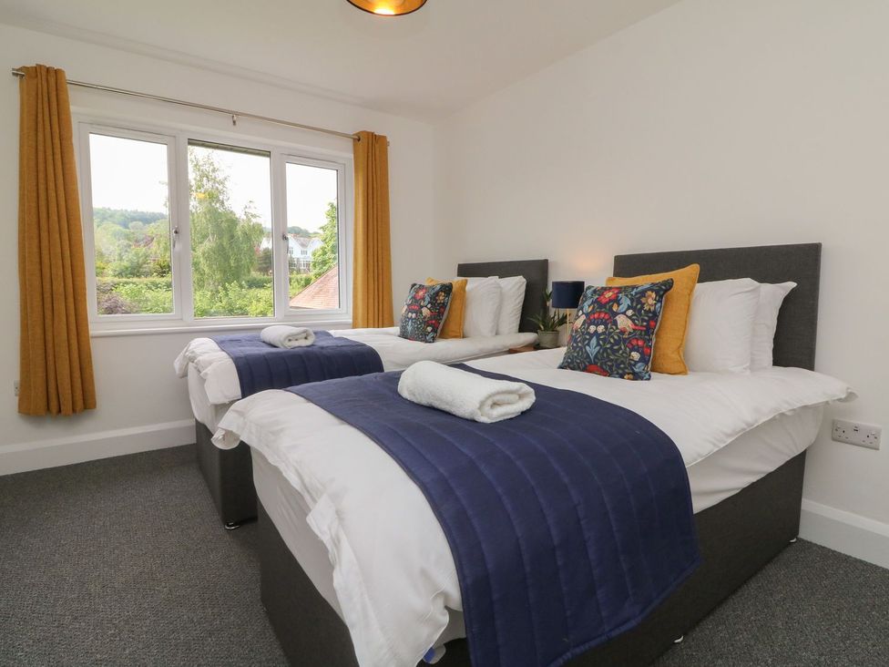 A bedroom with twin beds and a window at Wendy's Cottage in Minehead