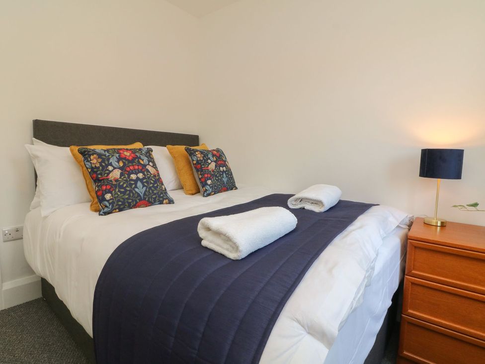A bedroom with a double bed and bedside lamp at Wendy's Cottage in Minehead