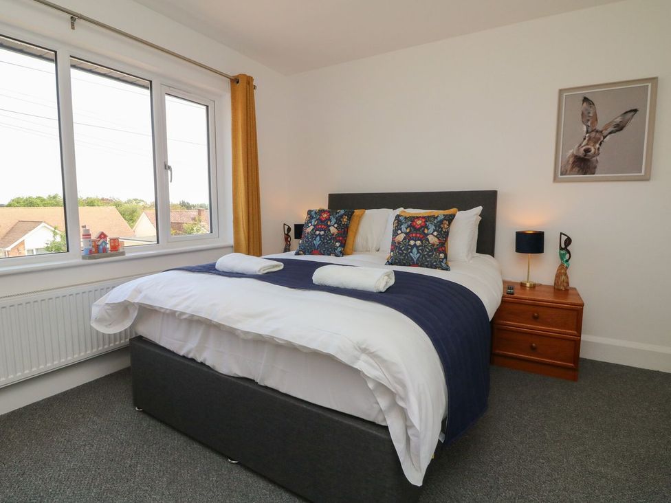 A bedroom with a bed and window at Wendy's Cottage Minehead