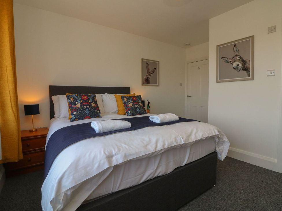 A bedroom with a bed and artwork at Wendy's Cottage in Minehead