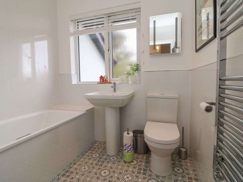 A bathroom with a sink, toilet, and bath at Wendy's Cottage in Minehead