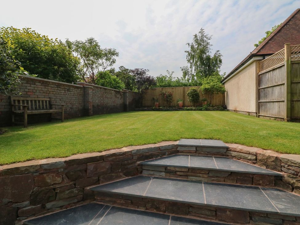 A garden with a grass lawn and steps at Wendy's Cottage in Minehead