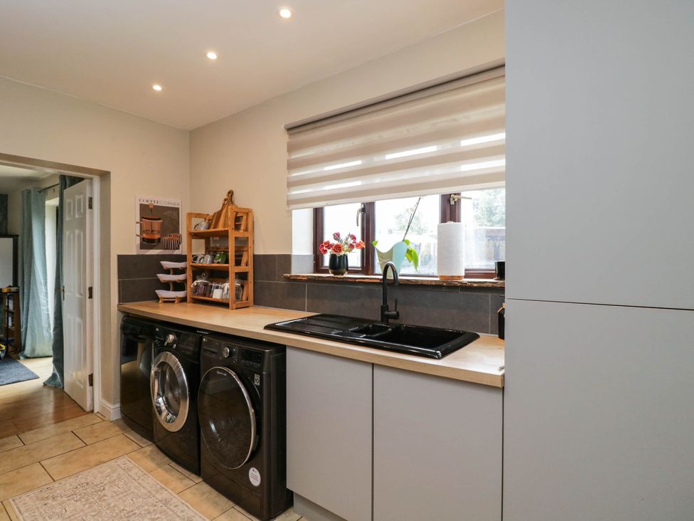 A kitchen with a sink and washing machine at 1 Stanway Road 