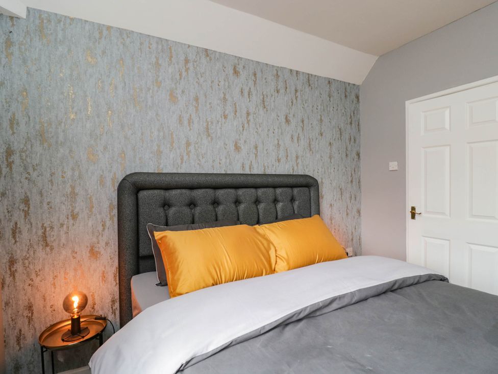 A bedroom with a bed and bedside table at 1 Stanway Road
