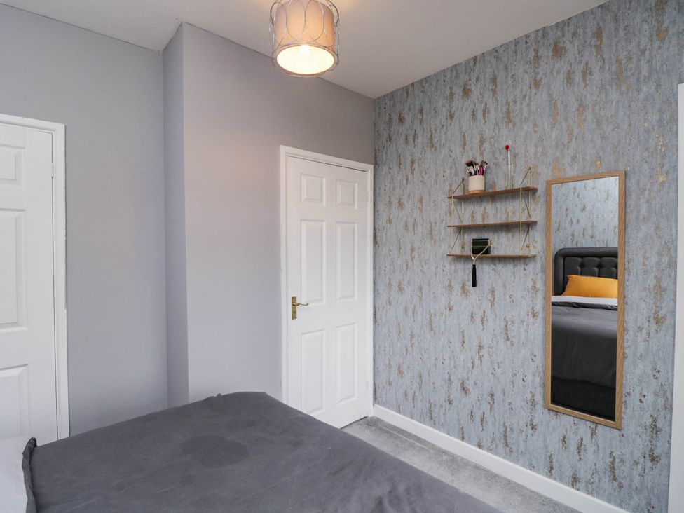 A bedroom with a bed and a mirror at 1 Stanway Road