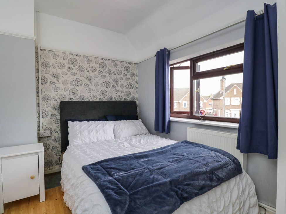 A bedroom with a bed and bedside table at 1 Stanway Road